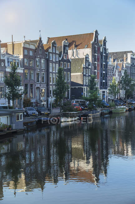 Extérieurs du bâtiment reflétés dans le canal, Amsterdam, Pays-Bas — Photo de stock