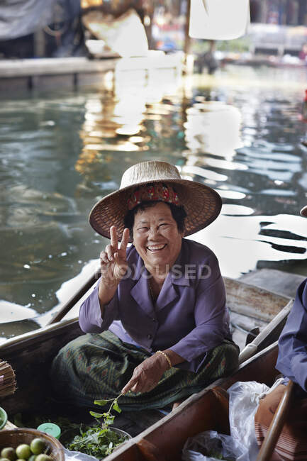 Portrait of happy senior female market stall holder, Damnoen Saduak Floating Market, Thailand — Stock Photo