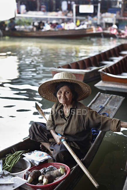 Retrato del tenedor del puesto del mercado femenino senior, Damnoen Saduak Floating Market, Tailandia - foto de stock