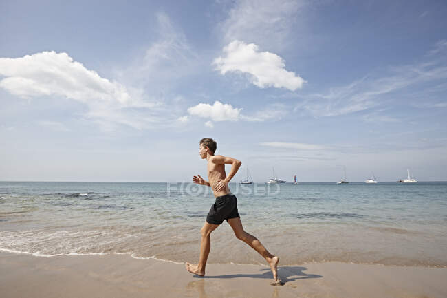 Joven corriendo por la orilla del mar, Koh Lipe, Tailandia - foto de stock
