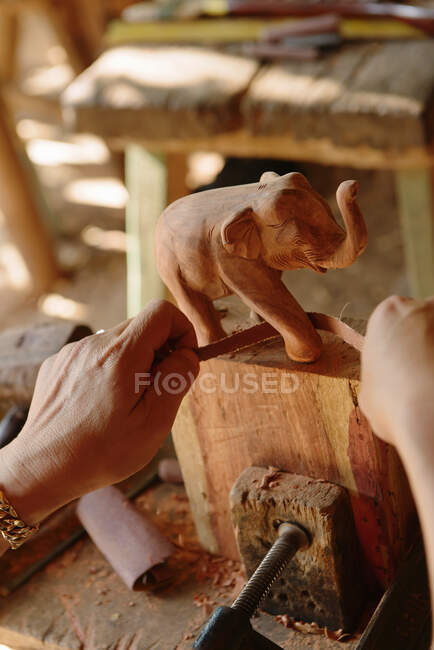 Primer plano de carpinteros tallando un elefante de madera - foto de stock