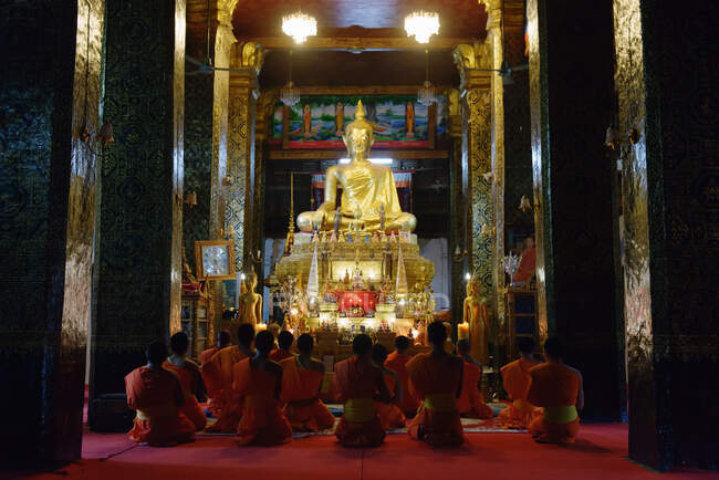 Monges e noviços orando em templo budista, Luang Prabang, Las — Fotografia de Stock