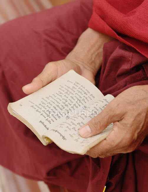 Primer plano del monje budista sosteniendo el libro de escrituras, Birmania - foto de stock