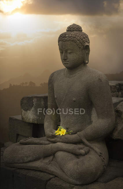 Ofrenda de flores y buddha, El templo budista de Borobudur, Java, Indonesia - foto de stock