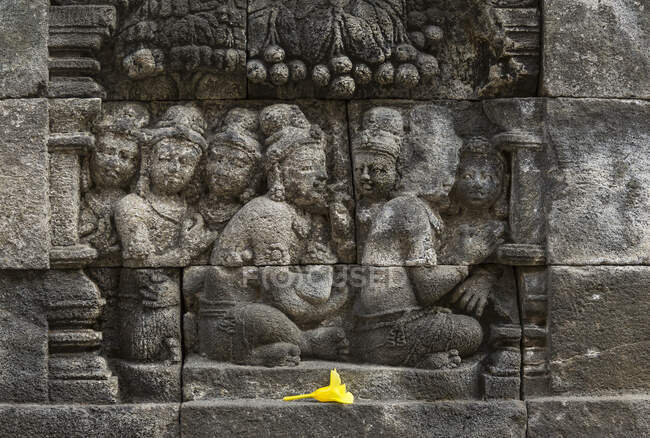 Flower offering and carvings, The Buddhist Temple of Borobudur, Java, Indonesia — Stock Photo