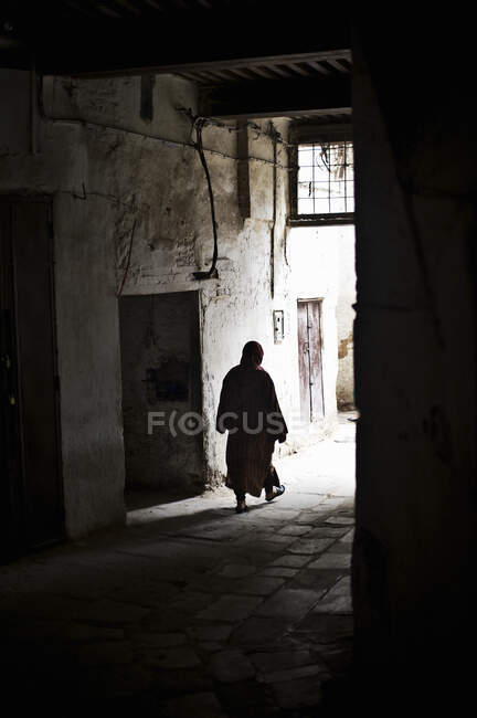 Silhouette of woman walking through alleyway, Fes Medina, Morocco — Stock Photo