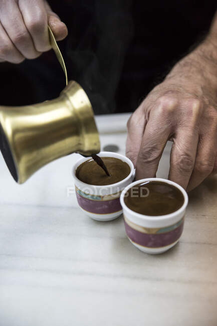 Ältere männliche Hände schenken traditionellen marokkanischen Kaffee ein — Stockfoto