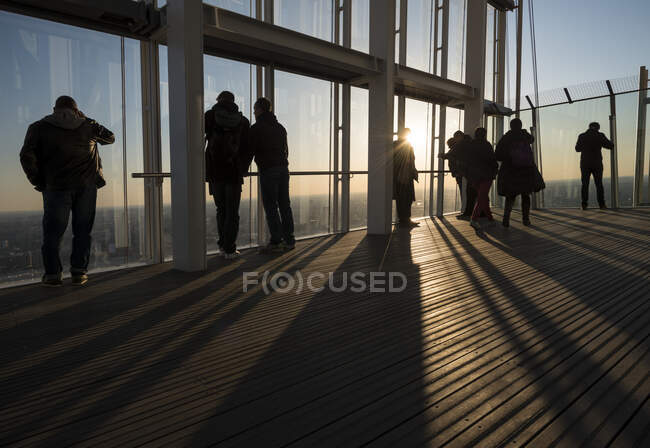 Grupo de turistas fotografiando desde la azotea de un rascacielos, Londres, Reino Unido - foto de stock