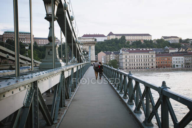 Пара, гуляющая по Цепному мосту, река Дунай, Будапешт, Венгрия — стоковое фото