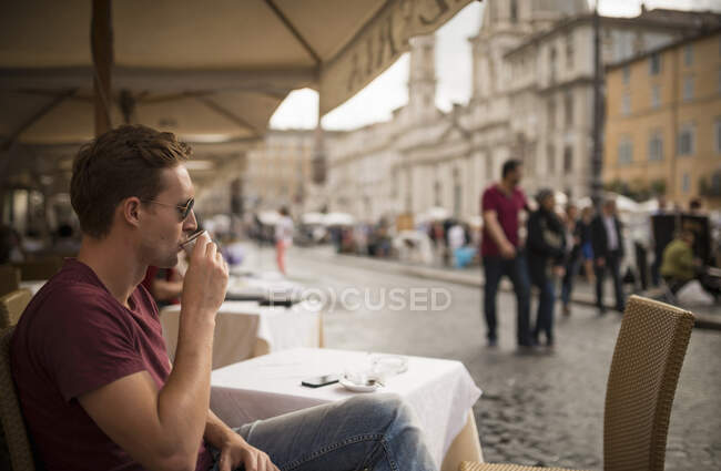 Человек, наслаждающийся эспрессо в ресторане, Пьяцца Навона, Рим, Италия — стоковое фото