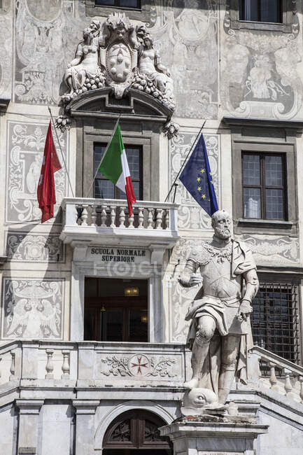 Estátua e bandeiras fora da universidade de Pisa, Pisa, Toscana, Itália — Fotografia de Stock