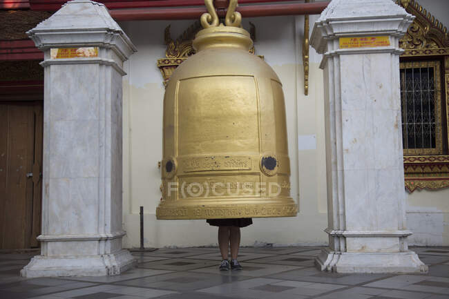 Fille debout à l'intérieur cloche géante, Wat Phra That Doi Suthep, Chiang Mai, Thaïlande — Photo de stock