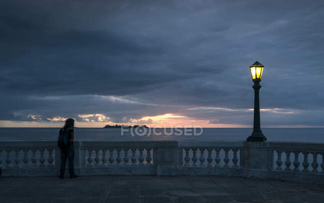 Der Mann blickt vom Barrio Historico (Altstadt), Colonia del Sacramento, Colonia, Uruguay auf den Sonnenuntergang über dem Meer — Stockfoto