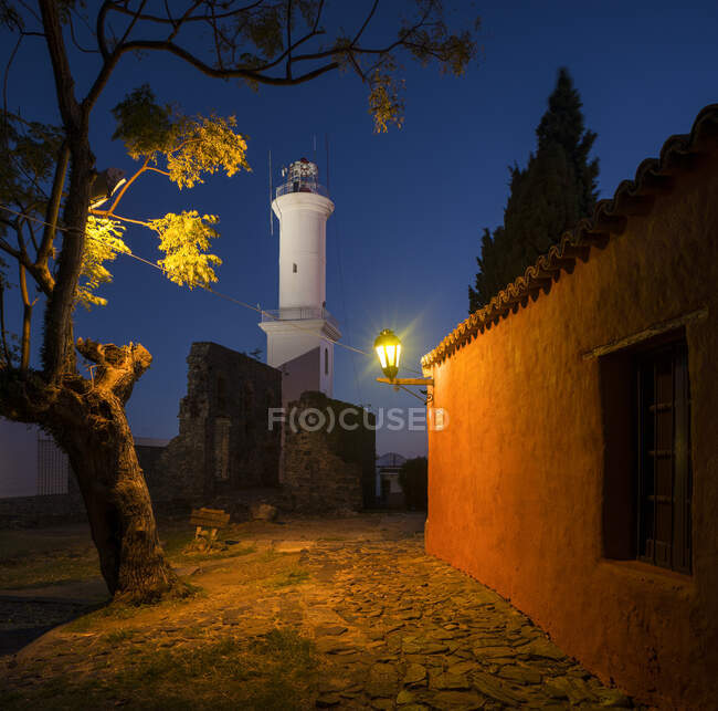 Vue du phare la nuit depuis la rue pavée, Barrio Historico (Vieux Quartier), Colonia del Sacramento, Colonia, Uruguay — Photo de stock