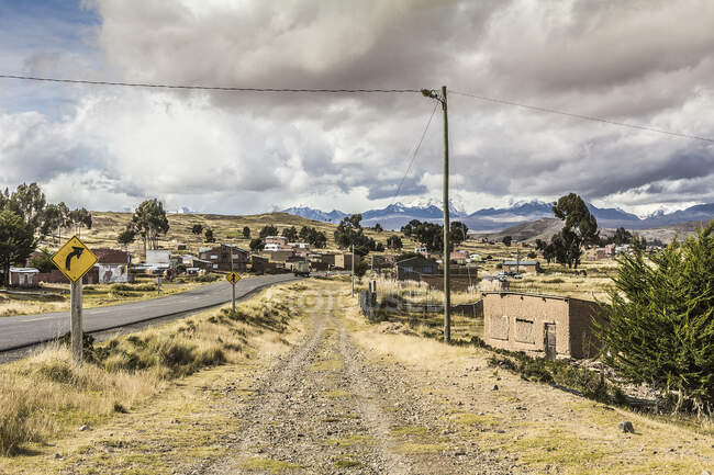 Carretera y pueblo rural, Altiplano, Bolivia, Sudamérica - foto de stock