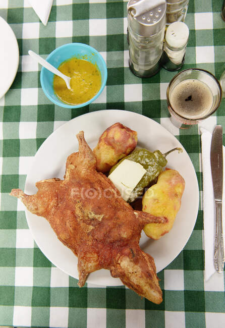 Table with meal of roasted guinea pig with potato, green pepper and cheese (cuy, rocoto relleno), Cusco, Peru, South America — Stock Photo