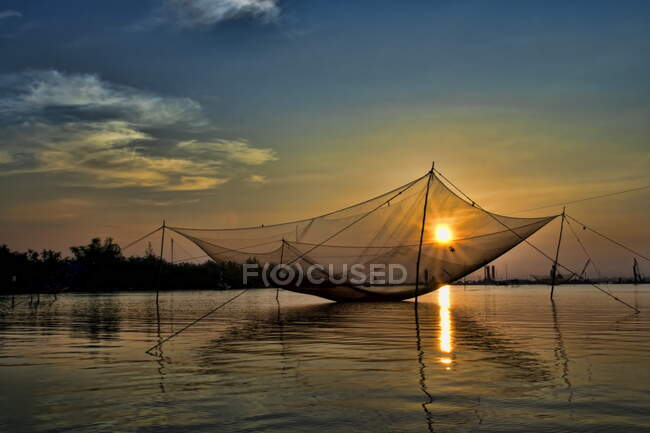 Rede de pesca inclinada sobre o rio ao pôr do sol, Hoi An, Vietnã — Fotografia de Stock