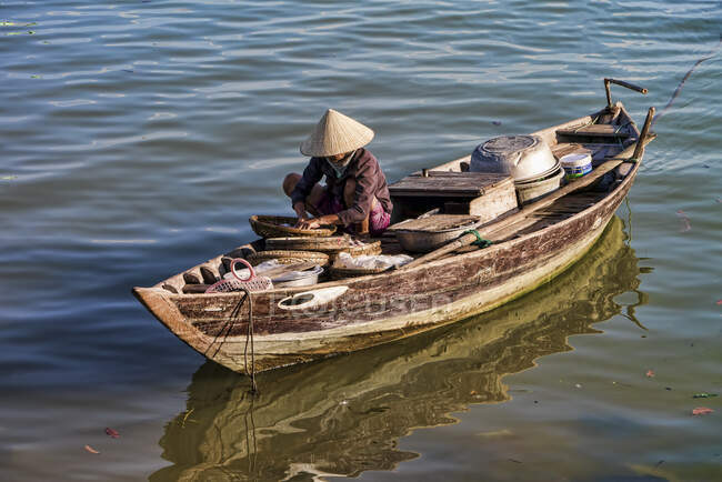 Рыбак, сидящий на лодке в реке Хойан, Вьетнам — стоковое фото