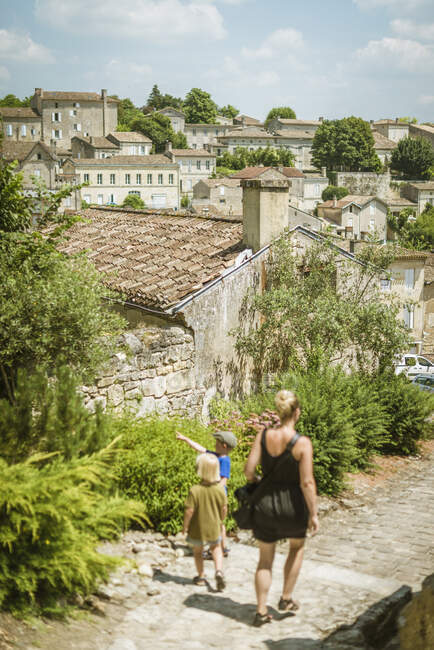 Touristin und zwei Söhne spazieren in Saint-Emilion, Aquitanien, Frankreich — Stockfoto