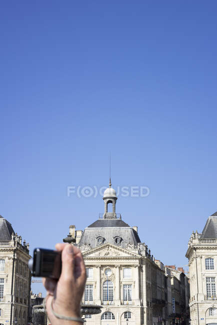 Person photing building, Bordeaux, France — стокове фото