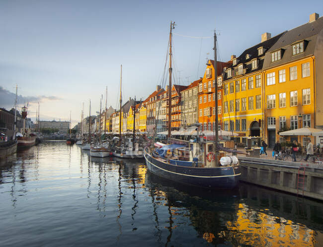 Barcos de vela, restaurantes en la acera y coloridas casas adosadas en New harbor, Copenhague, Dinamarca - foto de stock