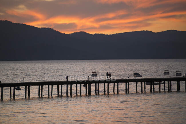 Silhouetted view of pier on South Lake Tahoe at sunset, California, USA — Stock Photo