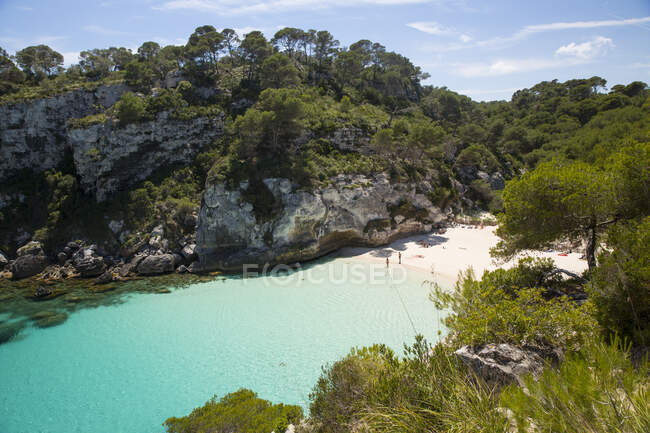 Vista lejana de los turistas en la playa, Cala Macarelleta, Menorca, España - foto de stock