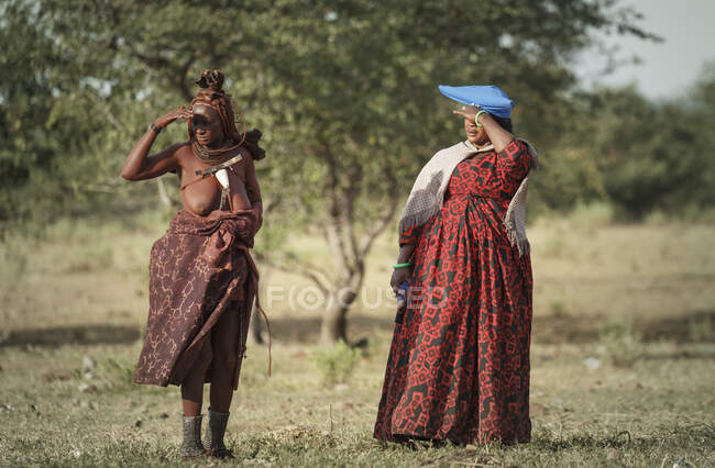 Duas mulheres Himba sombreando os olhos do sol, Namíbia, África — Fotografia de Stock