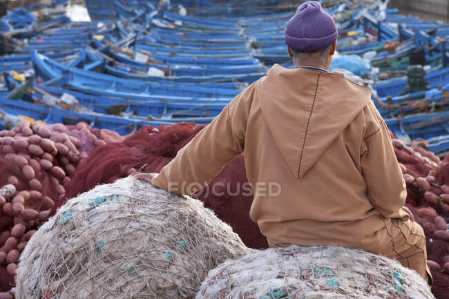 Homem local sentado no porto de pesca, vista traseira, Essauira, Marrocos — Fotografia de Stock