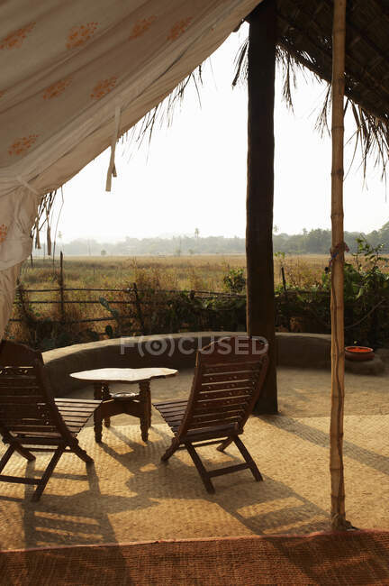 Table and chairs under canopy at eco retreat, Goa, India — Stock Photo