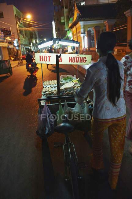 Уличный торговец и велосипедист ночью, Кантхо, Вьетнам — стоковое фото