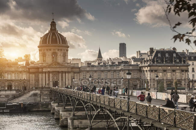 Туристы, пересекающие пешеходный мост через реку Сена, Париж, Франция — стоковое фото