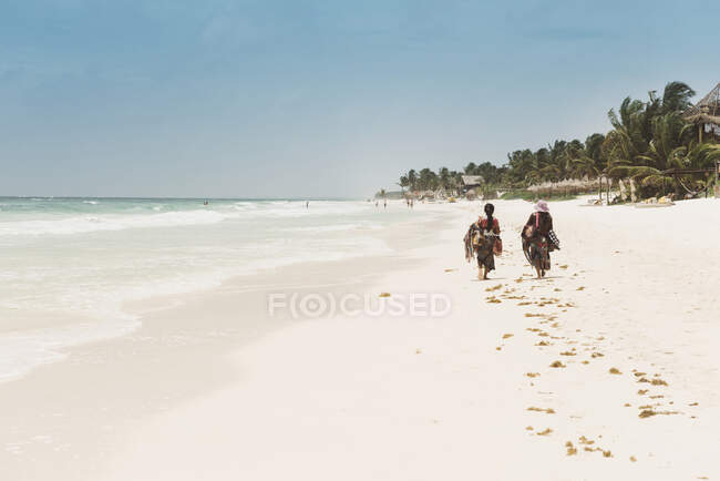 Deux personnes locales marchant le long de la plage, Tulum, Mexique — Photo de stock