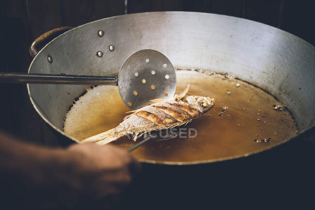 Persona cocinando pescado en sartén, primer plano, Tulum, México - foto de stock