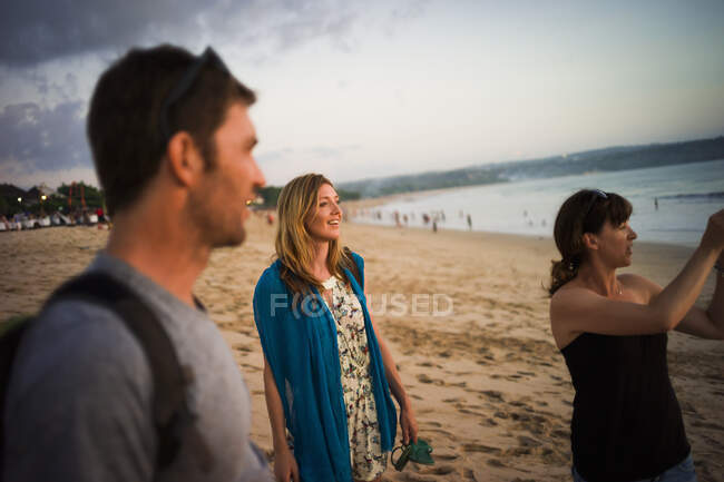 Group of friends walking on beach, Jimbaran Bay, Bali, Indonesia — Stock Photo