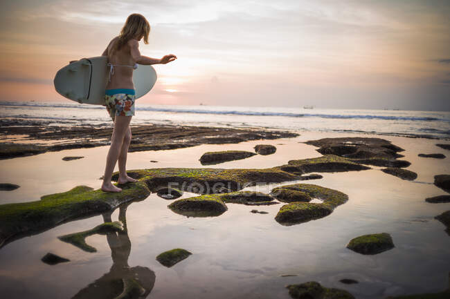 Жінка тримає серфінг, ідучи до моря, Баланган, Балі, Індонезія. — стокове фото