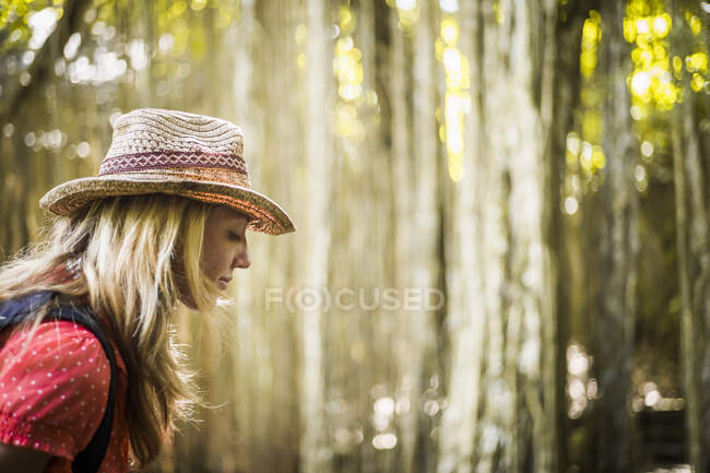 Perfil de mid adult woman wearing hat in forest, Ubud, Bali, Indonesia — Fotografia de Stock
