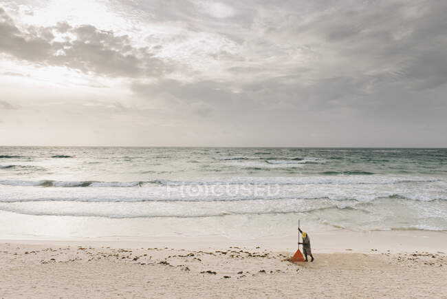 Uomo locale che rastrella sabbia sulla spiaggia, Tulum, Messico — Foto stock