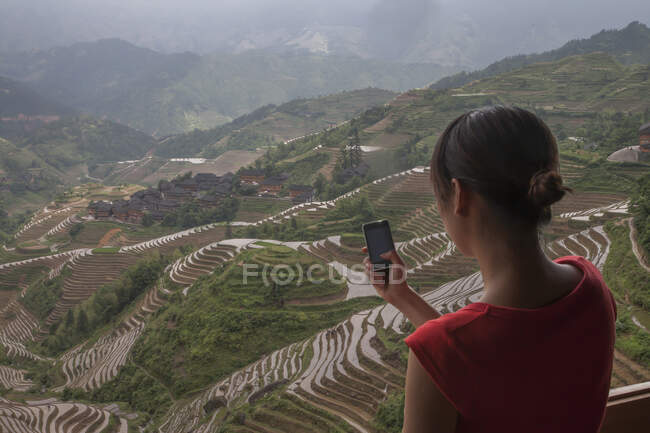 Mujer joven tomando fotos, Longsheng, provincia de Guangxi, China - foto de stock