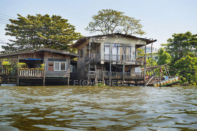 Casas de madera en el río, Bangkok, Tailandia - foto de stock