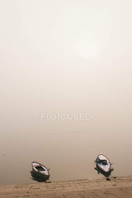 Due barche da pesca sul bordo delle acque, Varanasi, Uttar Pradesh, India — Foto stock