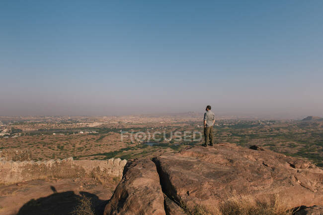 Человек, стоящий на скале в Рао Джодха Desert Rock Park, Джодхпур, Радж — стоковое фото