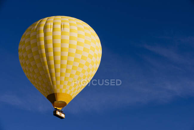 Mongolfiera gialla galleggiante contro il cielo blu, Goreme Nationa — Foto stock