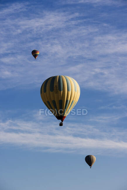 Tres globos de aire caliente flotando contra el cielo azul, Goreme Nationa - foto de stock