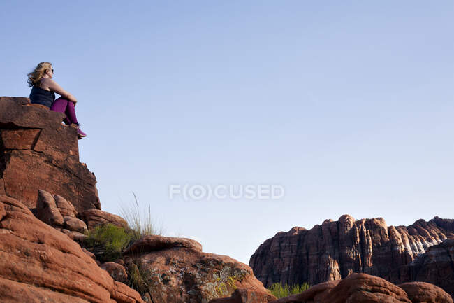 Caminhante feminina olhando para fora do topo da formação de rocha em Snow Can — Fotografia de Stock