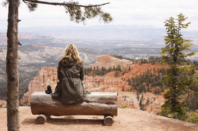 Rear view of female hiker looking out from log bench at Bryce Ca — Stock Photo