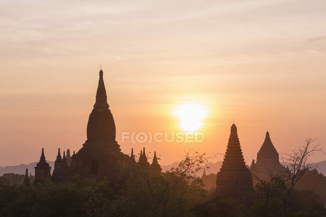 Silhouettierte Tempel bei Sonnenuntergang von der Dhammayazika-Pagode aus gesehen — Stockfoto