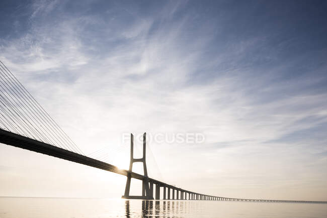 Puente Vasco Da Gama contra el cielo dramático, Río Tajo, Lisboa - foto de stock