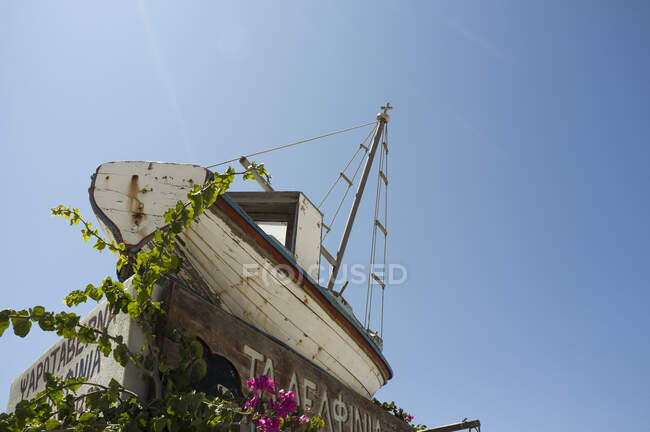 Низкий угол обзора старой рыбацкой лодки и голубого неба, Фира, Санторини — стоковое фото