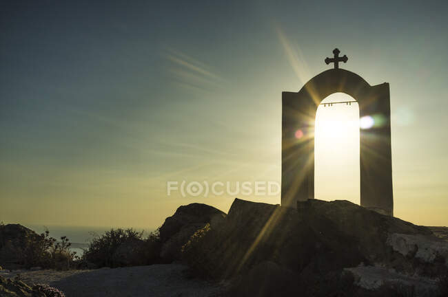Vista do arco religioso e cruz ao pôr do sol, Oia, Santorini, Gree — Fotografia de Stock